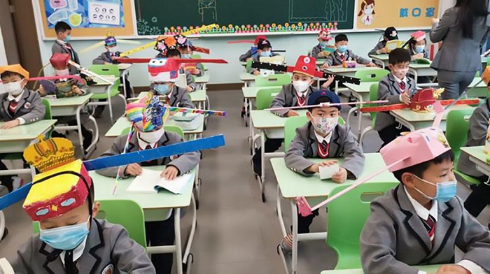 Los niños de China vuelven a clases con sombreros de dos metros para respetar la distancia de seguridad